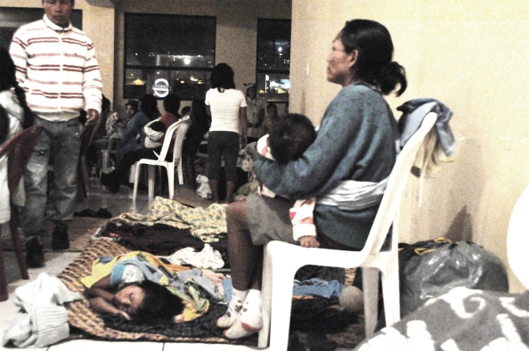 Una mujer cuida a sus niños mientras escucha un recital del Chamo Guevara en la sede de la CONAIE